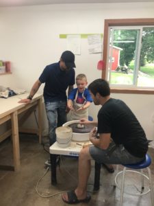 Brian Smith helping out a future potter during a Coyote After Dark